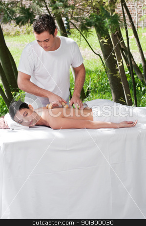 Man giving massage to woman by a wooden massager Man giving massage to woman by a wooden massager stock photo, Young man giving massage to woman by a wooden massager by Tyler Olson