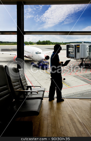 Airport Terminal Laptop Airport Terminal Laptop stock photo, A young man using a laptop in an airport terminal by Tyler Olson