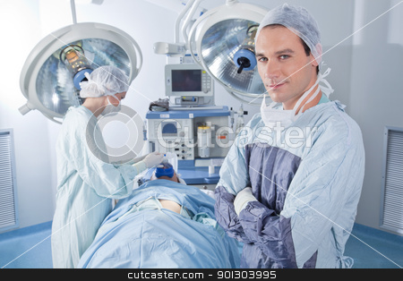 Confident surgeon in operating room - medical stock photos Confident surgeon in operating room - medical stock photos stock photo, Smiling male doctor with arms crossed in operating room - medical stock photos by Tyler Olson