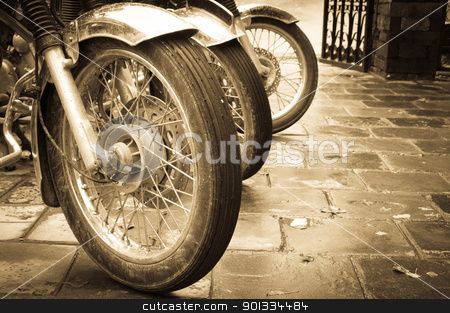 Bikes in a row Bikes in a row stock photo, Line of the muddy bikes whells in sepia by Iryna Rasko