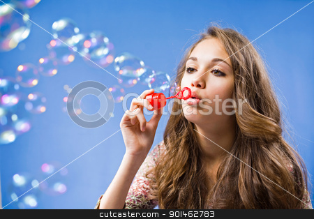 Free the bubbles Free the bubbles stock photo, Gorgeous young brunette girl blowing soap bubbles on blue background. by exvivo