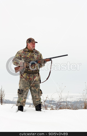 Hunter Hunter stock photo, Male hunter in camouflage,holding his gun and looking for his target or prey .Winter scene by borojoint
