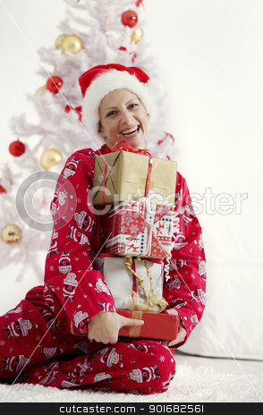 Christmas christmas stock photo, young woman in christmas pajamas holding a bunch of christmas presents by Liv Friis-Larsen