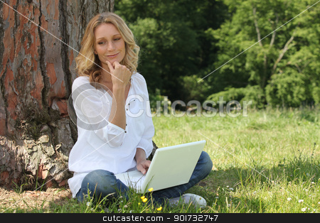 Woman using laptop in park Woman using laptop in park stock photo, Woman using laptop in park by photography33
