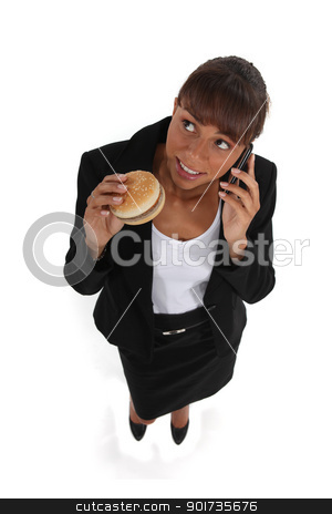 Businesswoman eating a hamburger and talking on her cell businesswoman eating a hamburger and talking on her cell stock photo, businesswoman eating a hamburger and talking on her cell by photography33