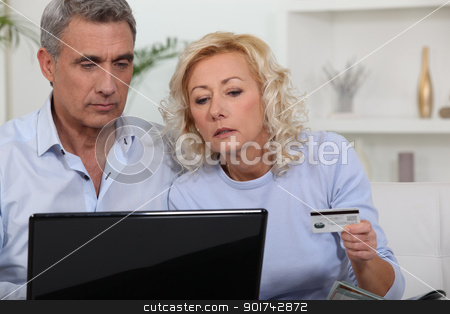 Middle aged couple shopping online. Middle aged couple shopping online. stock photo, Middle aged couple shopping online. by photography33