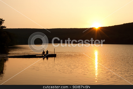 To use this stock image in your creative project, please select the size you need over to the right and click the "Add to Cart" button.
Your downloaded image will come with the Cutcaster watermark removed so don’t worry about the watermark you see on this page. Sunset at the Lake stock photo, A couple sitting on a boat dock watching reflections on as the sun sinks over the mountain. by Delmas Lehman