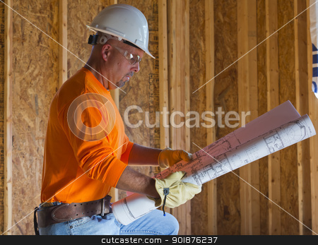 Male Construction Worker Male Construction Worker stock photo, A male construction worker reads blueprints while working at a construction site by Walter Arce