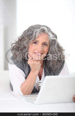 To use this stock image in your creative project, please select the size you need over to the right and click the "Add to Cart" button.
Your downloaded image will come with the Cutcaster watermark removed so don’t worry about the watermark you see on this page. Older woman using a laptop computer stock photo, Older woman using a laptop computer by photography33