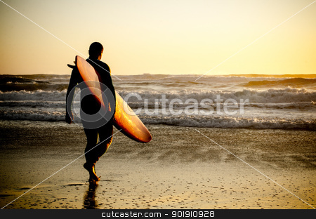 Surfer walking Surfer walking stock photo, Surfer walking on the beach with the waves at sunset in Portugal. by Homydesign