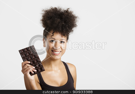 Woman with a chocolate bar Woman with a chocolate bar stock photo, Beautiful african woman holding a huge dark chocolate bar by ikostudio