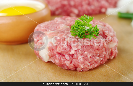 Raw Meatball Raw Meatball stock photo, Raw meatball garnished with a parsley leaf and a raw egg, green onion pieces and mincemeat in the back (Very Shallow Depth of Field, Focus on the front of the meatball and the leaf) by Ildiko Papp