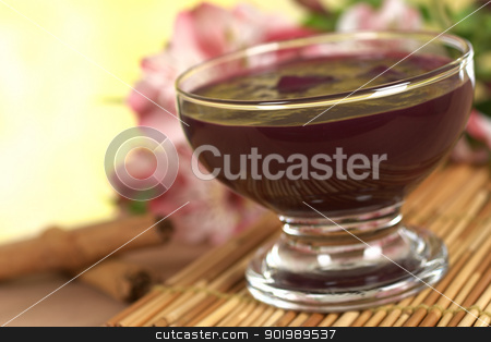 Peruvian Dessert Called Mazamorra Morada Peruvian Dessert Called Mazamorra Morada stock photo, Popular Peruvian dessert called Mazamorra Morada (made out of purple corn) with cinnamon sticks and pink inca lily in the back (Selective Focus, Focus on the front of the bowl) by Ildiko Papp