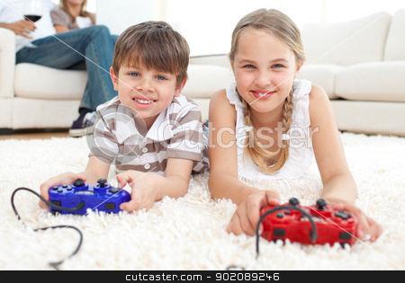 Cute brother and sister playing video games Cute brother and sister playing video games stock photo, Cute brother and sister playing video games lying on the floor by Wavebreak Media