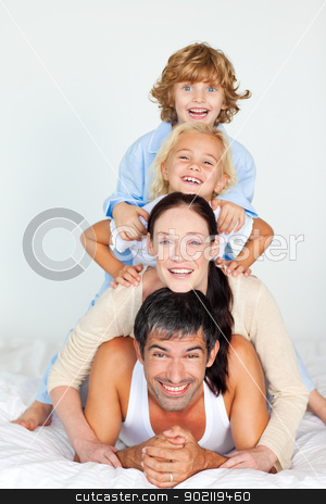 Parents and children playing in bed Parents and children playing in bed stock photo, Parents and children playing together in bed by Wavebreak Media