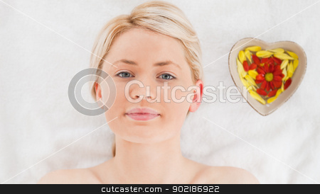 Pretty blonde woman lying down near flower petals Pretty blonde woman lying down near flower petals stock photo, Pretty blonde woman lying down near flower petals in a Spa centre by Wavebreak Media
