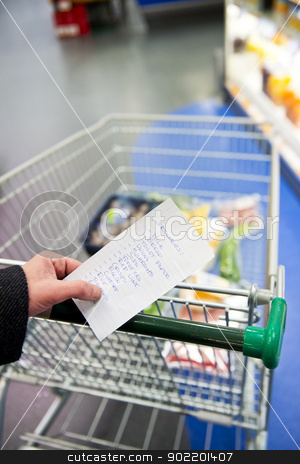 Shopping cart and groceries Shopping cart and groceries stock photo, Hand, holding a shopping list with day to day groceries and other necessities, whilst pushing a shopping cart through a supermarket by Corepics VOF