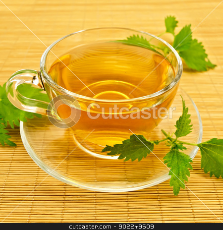 Herbal tea with nettles on a bamboo mat Herbal tea with nettles on a bamboo mat stock photo, Herbal tea in a glass cup and saucer, three twig nettle on a bamboo napkin by rezkrr