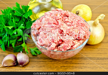Minced meat on the board Minced meat on the board stock photo, Minced meat in a glass bowl, parsley, onions, a bottle of vegetable oil, garlic on a wooden board by rezkrr