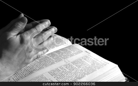 Bible Bible stock photo, A mans hands clasped in prayer over a Bible by Vitaliy Pakhnyushchyy