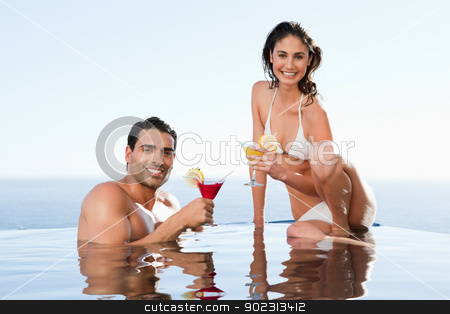 To use this stock image in your creative project, please select the size you need over to the right and click the "Add to Cart" button.
Your downloaded image will come with the Cutcaster watermark removed so don’t worry about the watermark you see on this page. Cheerful couple having cocktails in the pool stock photo, Cheerful young couple having cocktails in the pool by Wavebreak Media