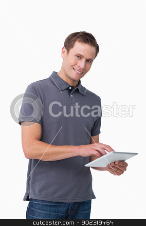 Smiling young man with tablet computer Smiling young man with tablet computer stock photo, Smiling young man with tablet computer against a white background by Wavebreak Media