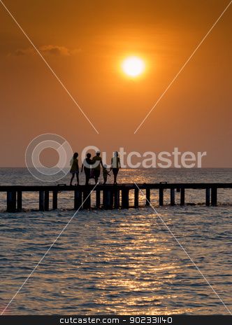 To use this stock image in your creative project, please select the size you need over to the right and click the "Add to Cart" button.
Your downloaded image will come with the Cutcaster watermark removed so don’t worry about the watermark you see on this page. Family crossing bridge at sunset stock photo, Silhouette of family walking over a bridge at sunset by Christian Delbert