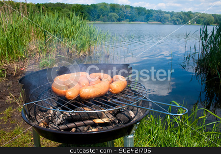 Grilling at summer weekend Grilling at summer weekend stock photo, Fresh sausage preparing on grill at the lakeshore by Jan Remisiewicz