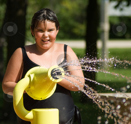 Girl Squirting Water stock photo A young girl playing in a water park 