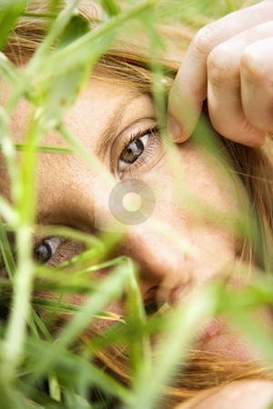 Female portrait up close. Female portrait up close. stock photo, Close up portrait of pretty redhead lying in grass looking at viewer. by Iofoto Images