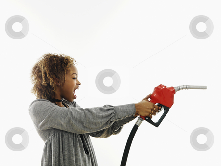 Angry woman with gas nozzle Angry woman with gas nozzle stock photo, Portrait of pretty young woman holding gas pump nozzle like a gun making angry facial expression on white background. by Iofoto Images