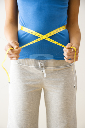 To use this stock image in your creative project, please select the size you need over to the right and click the "Add to Cart" button.
Your downloaded image will come with the Cutcaster watermark removed so don’t worry about the watermark you see on this page. Measuring waist stock photo, Woman standing pulling measuring tape around waist. by Iofoto Images