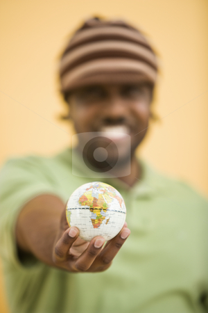 To use this stock image in your creative project, please select the size you need over to the right and click the "Add to Cart" button.
Your downloaded image will come with the Cutcaster watermark removed so don’t worry about the watermark you see on this page. Man with small globe. stock photo, African-American mid-adult man wearing hat holding small globe to viewer. by Iofoto Images
