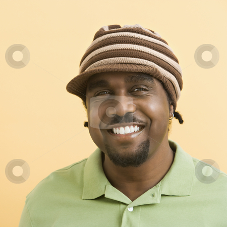 To use this stock image in your creative project, please select the size you need over to the right and click the "Add to Cart" button.
Your downloaded image will come with the Cutcaster watermark removed so don’t worry about the watermark you see on this page. Handsome man in hat. stock photo, African-American mid-adult man wearing knit hat with brim smiling at viewer. by Iofoto Images
