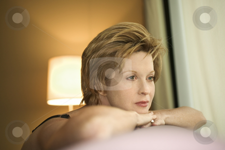 Portrait of woman. Portrait of woman. stock photo, Portrait of pretty Caucasian woman draped over sofa by window looking out. by Iofoto Images