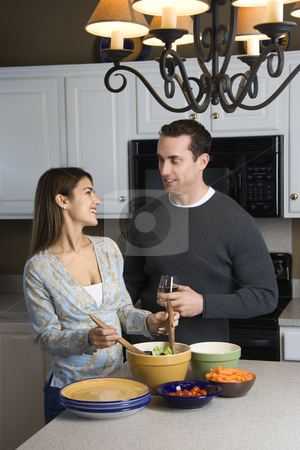 Couple in kitchen. Couple in kitchen. stock photo, Caucasian couple making salad at kitchen counter. by Iofoto Images