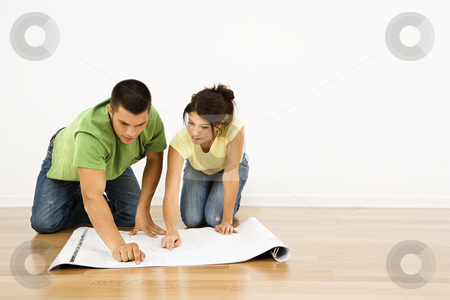 Couple with house plans. Couple with house plans. stock photo, Attractive young adult couple looking at house plans. by Iofoto Images