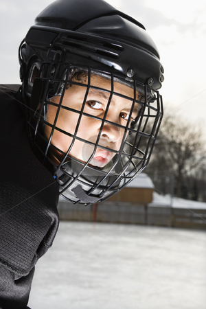 Ice hockey player boy. Ice hockey player boy. stock photo, Ice hockey player boy in uniform and cage helmet making mean face. by Iofoto Images