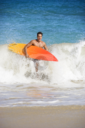 Surfer man. Surfer man. stock photo, Attractive young man running out of water carrying surfboard in Maui, Hawaii. by Iofoto Images