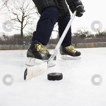 To use this stock image in your creative project, please select the size you need over to the right and click the "Add to Cart" button.
Your downloaded image will come with the Cutcaster watermark removed so don’t worry about the watermark you see on this page. Boy playing ice hockey. stock photo, Boy in ice hockey uniform skating on ice rink moving puck. by Iofoto Images