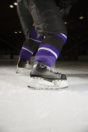 Ice hockey player. Ice hockey player. stock photo, Low angle of hockey player's legs and skates on ice rink. by Iofoto Images