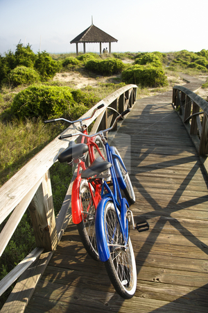 Bicycles at beach. Bicycles at beach. stock photo, Image of red and blue bike leaning against railing of boardwalk. by Iofoto Images