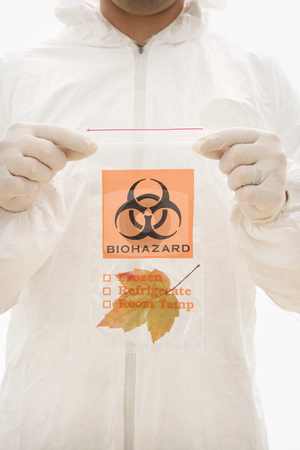 To use this stock image in your creative project, please select the size you need over to the right and click the "Add to Cart" button.
Your downloaded image will come with the Cutcaster watermark removed so don’t worry about the watermark you see on this page. Nature biohazard. stock photo, Man in biohazard suit and rubber gloves holding plastic biohazard bag containing orange Maple leaf. by Iofoto Images