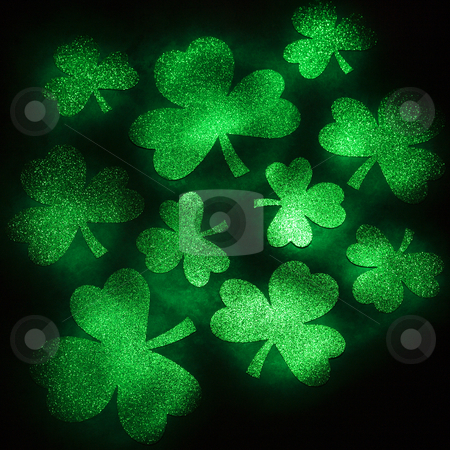 Green glitter shamrocks. Green glitter shamrocks. stock photo, Group of green shamrocks reflecting light on black background. by Iofoto Images