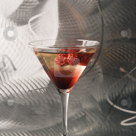Still life of martini. Still life of martini. stock photo, Still life of martini mixed drink with raspberry fruit agaisnt textured metallic background. by Iofoto Images