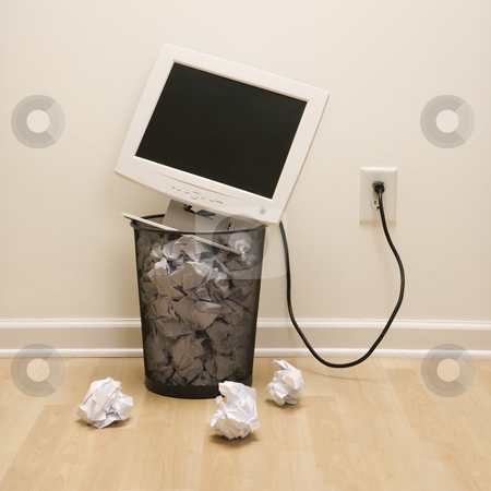 Computer in trash can. Computer in trash can. stock photo, Computer monitor in trash can surrounded by crumpled up paper. by Iofoto Images
