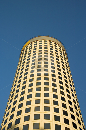 To use this stock image in your creative project, please select the size you need over to the right and click the "Add to Cart" button.
Your downloaded image will come with the Cutcaster watermark removed so don’t worry about the watermark you see on this page. Round Office Tower on Blue Sky stock photo, A tall and round form office building with more than 20 levels pictured from below on a blue sky. by Lee Torrens