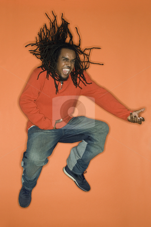 To use this stock image in your creative project, please select the size you need over to the right and click the "Add to Cart" button.
Your downloaded image will come with the Cutcaster watermark removed so don’t worry about the watermark you see on this page. Man jumping with enthusiasm. stock photo, African-American mid-adult man on orange background jumping while playing air guitar. by Iofoto Images