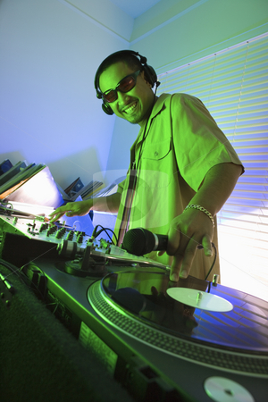 To use this stock image in your creative project, please select the size you need over to the right and click the "Add to Cart" button.
Your downloaded image will come with the Cutcaster watermark removed so don’t worry about the watermark you see on this page. Male DJ with hand on record. stock photo, Asian young adult male DJ wearing sunglasses behind mixing equipment with hand on record turntable looking at viewer smiling. by Iofoto Images