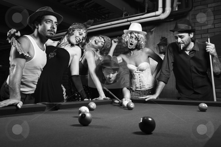 Retro group playing pool. Retro group playing pool. stock photo, Group of Caucasian prime adult retro males and females trying to distract man as he takes pool shot. by Iofoto Images